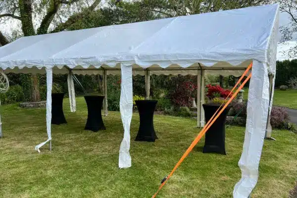 Installation d'un barnum 4x8 dans un jardin. Structure ouverte avec des tables mange-debout