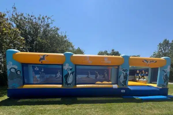 Aire de jeux gonflable avec grande piscine à balles pour enfants. Installée dans un grand jardin, vue de l'extérieur.